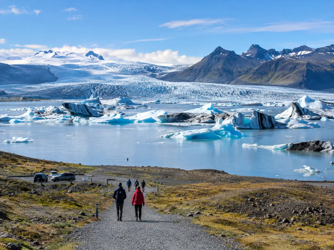 A gravel path leading from a small car park to a quiet glacier lagoon