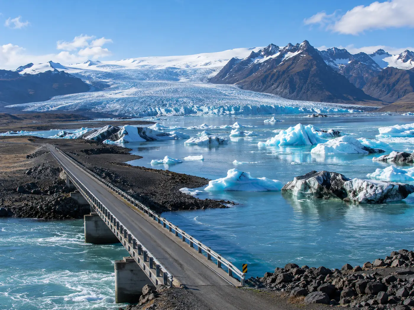 A narrow one-lane bridge on the Ring Road crossing a wide glacial river under grey sky